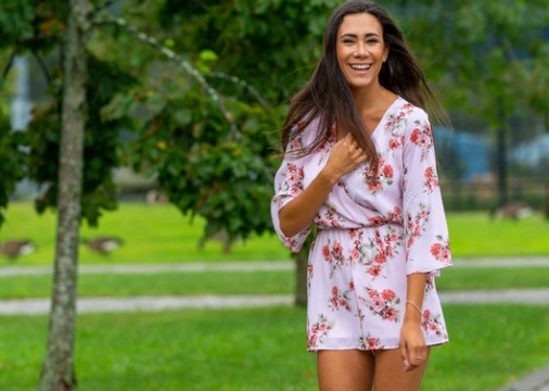 woman standing in jumpsuit outside with trees