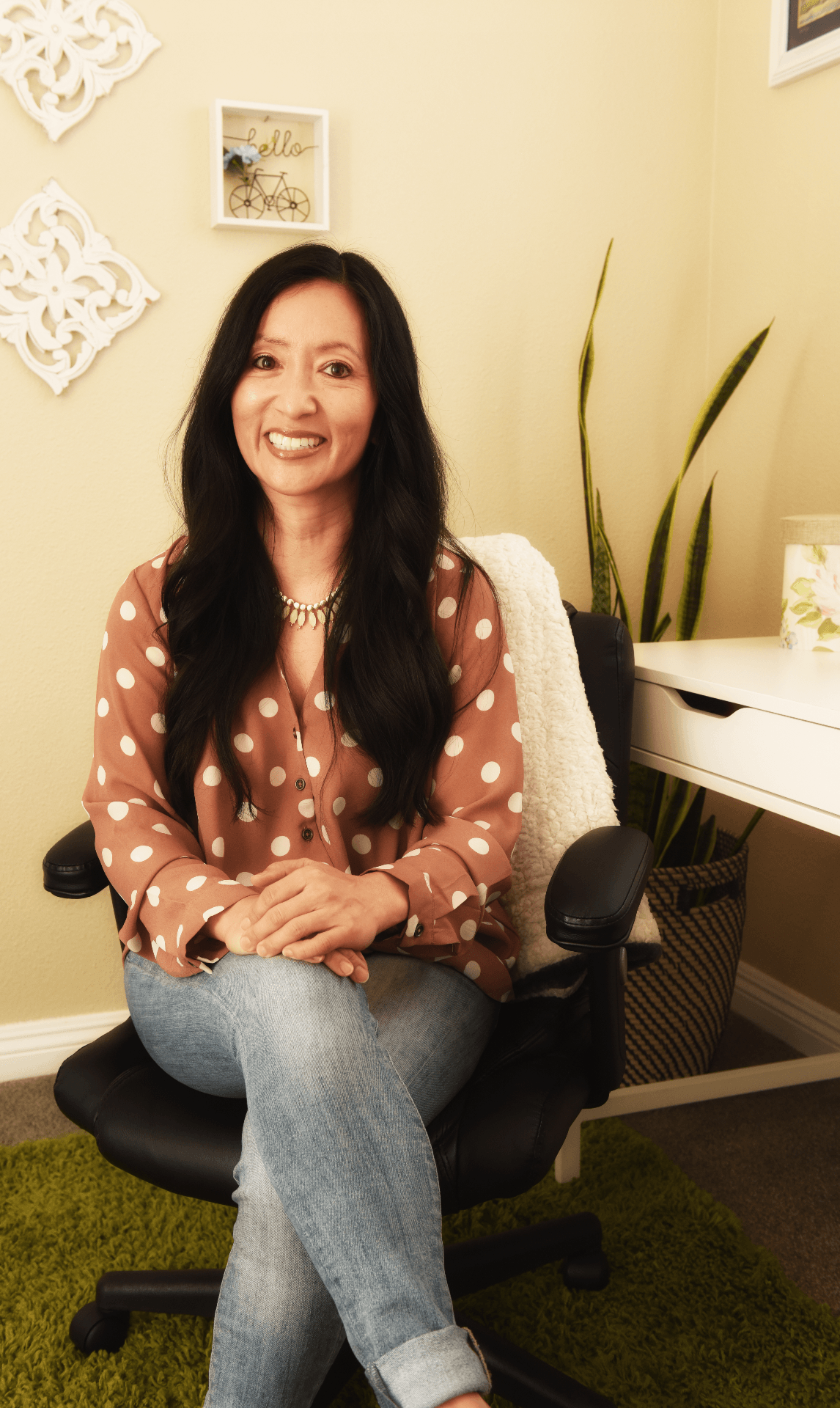 Lorin's profile picture with pink and white polka dot shirt sitting in office