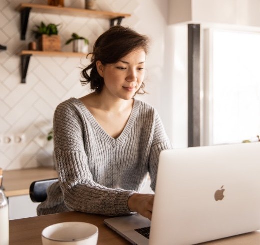 woman on laptop with coffee sitting at table