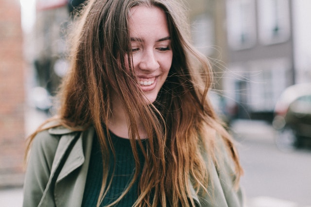 woman smiling side ways looking down in street