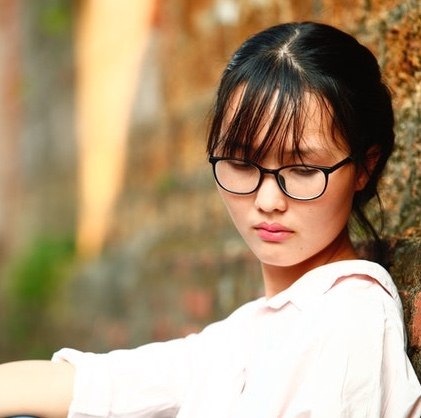 woman wearing glasses in sitting against tree