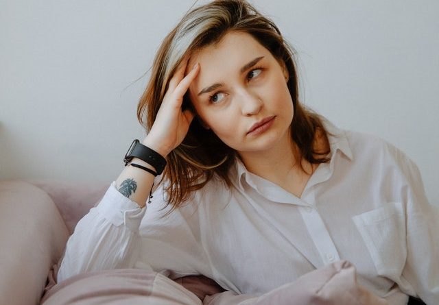 woman annoyed sitting looking awa  with hand on side of head